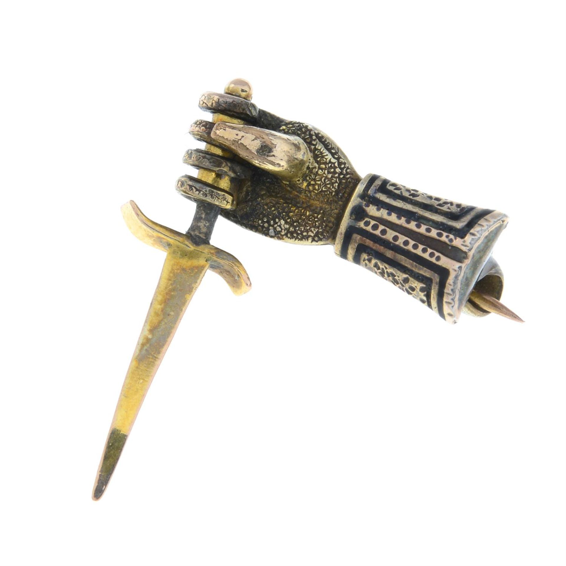 A late 19th century brooch, depicting an armoured hand holding a dagger.