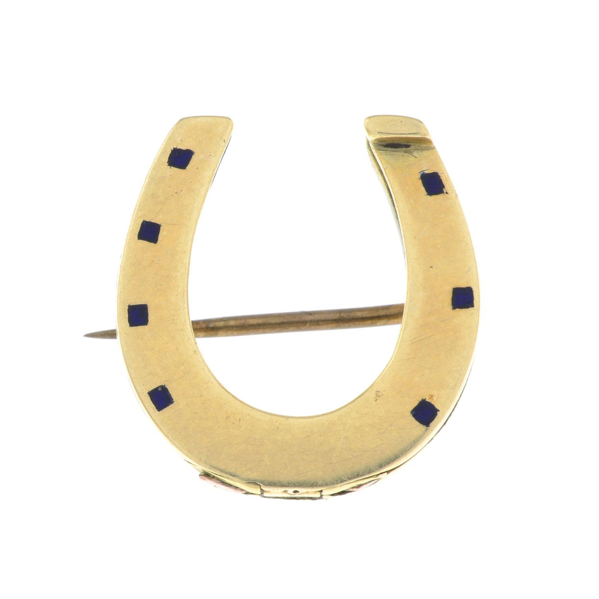 An early 20th century gold and blue enamel horseshoe brooch.