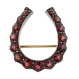 A late Victorian garnet horseshoe brooch.