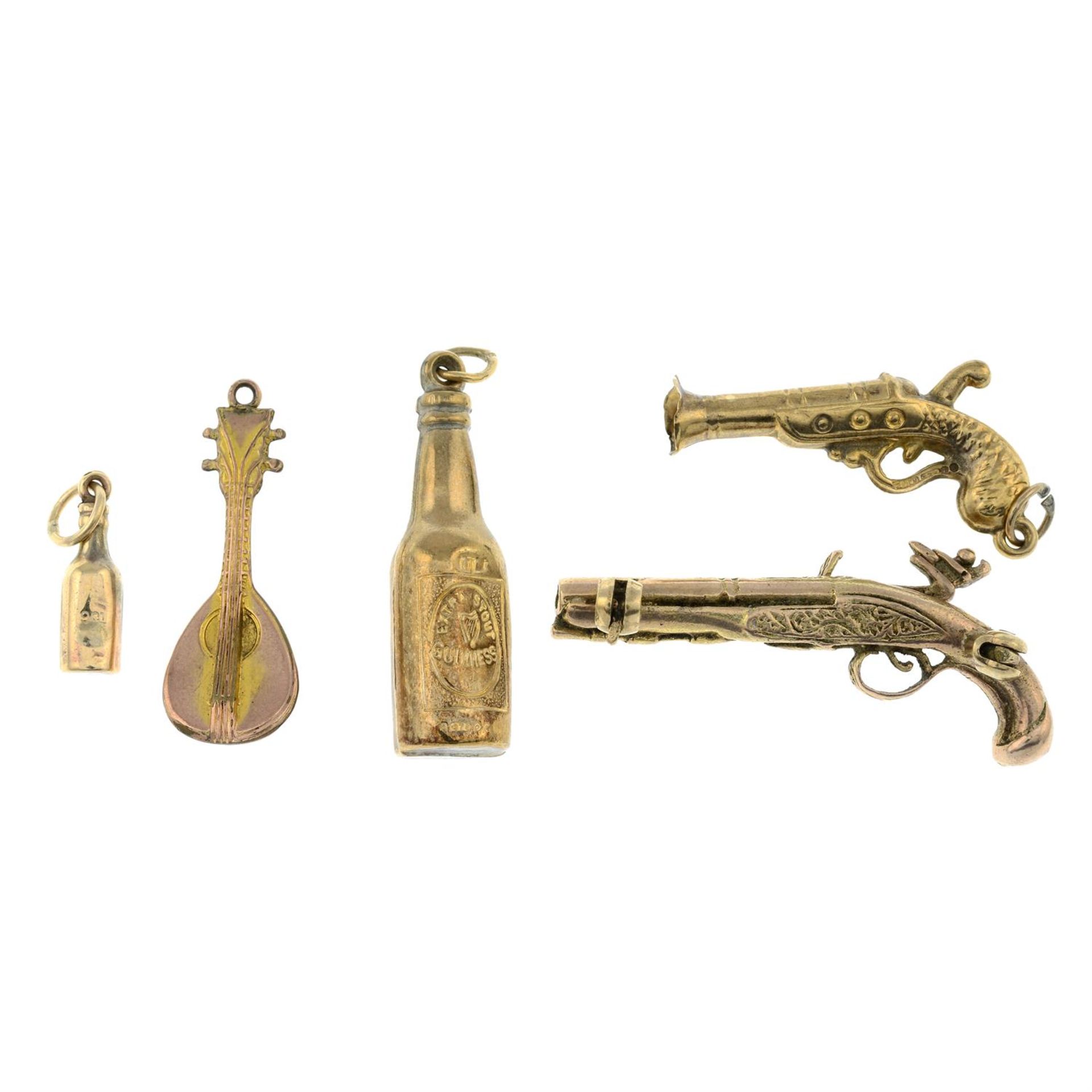 Three 9ct gold charms, together with a further charm and a 9ct gold pistol brooch.