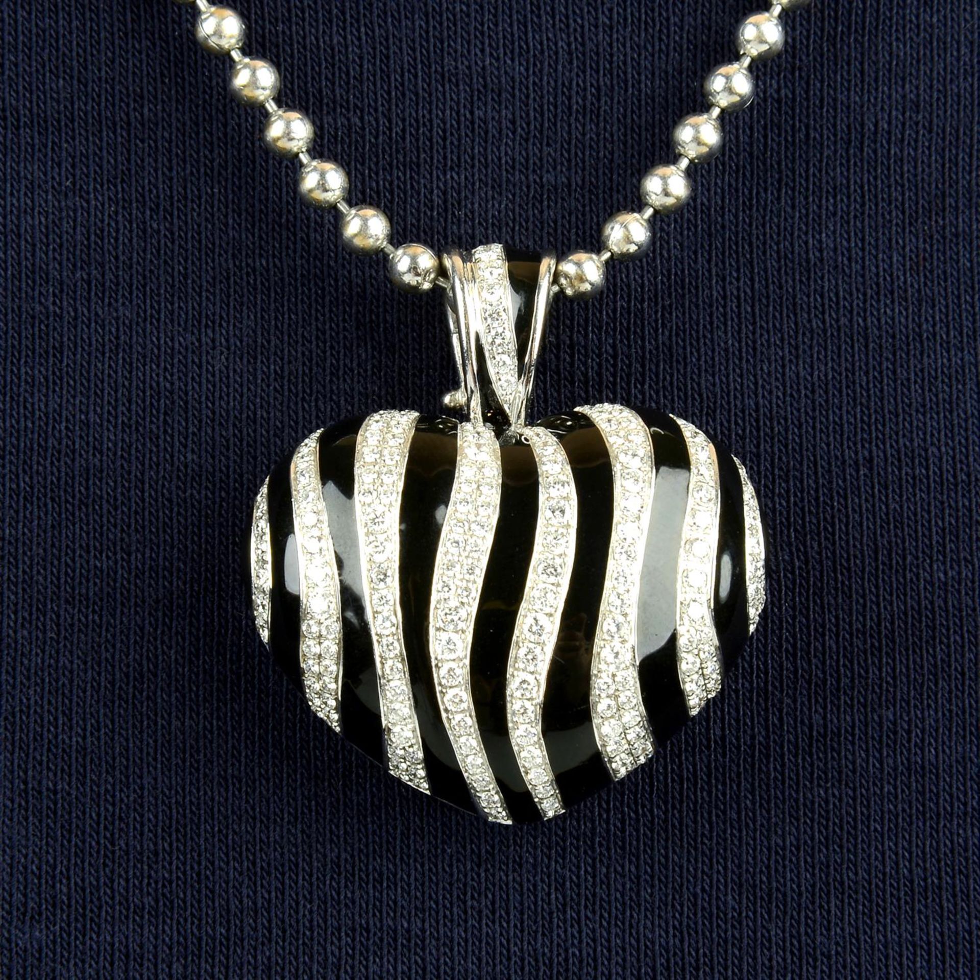 An 18ct gold pavé-set diamond and undulating black enamel striped heart pendant, with bead-link