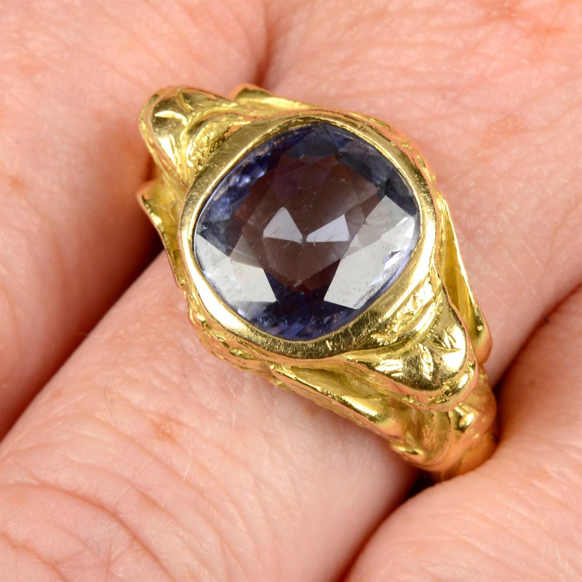 A Sri Lankan sapphire ring, with mythical winged creature shoulders and lion mask gallery.