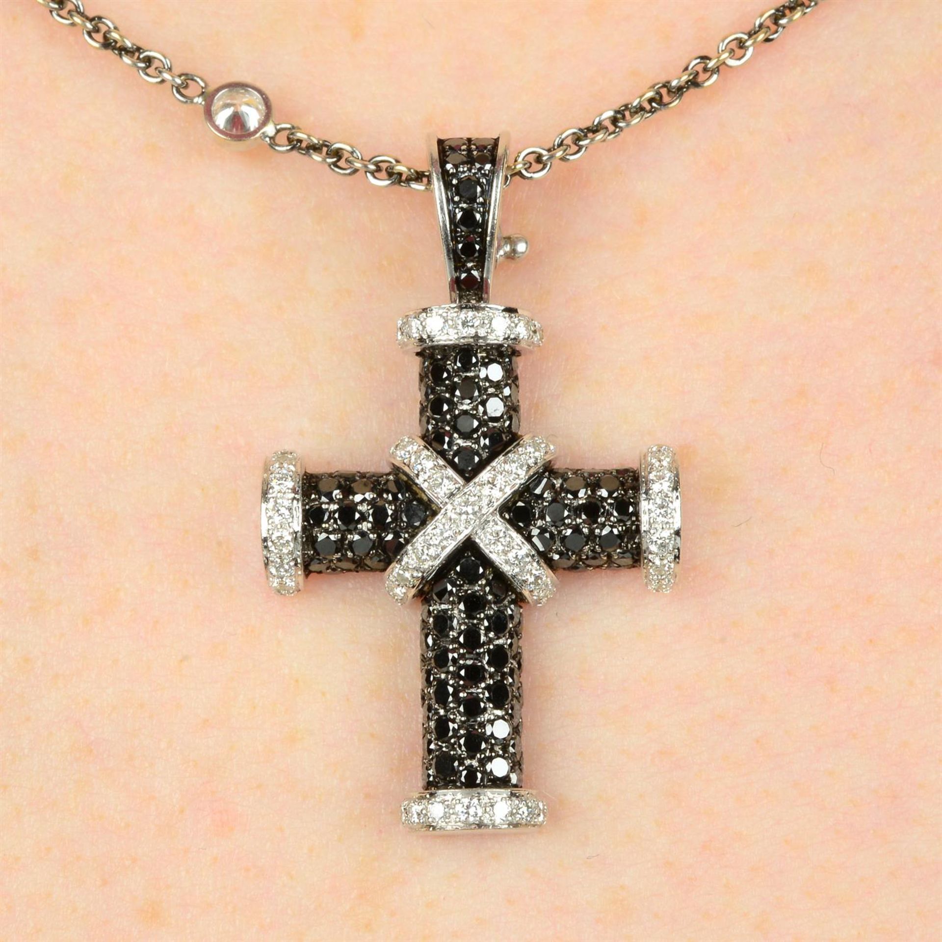 An 18ct gold diamond and 'black' diamond cross pendant, with diamond station necklace,