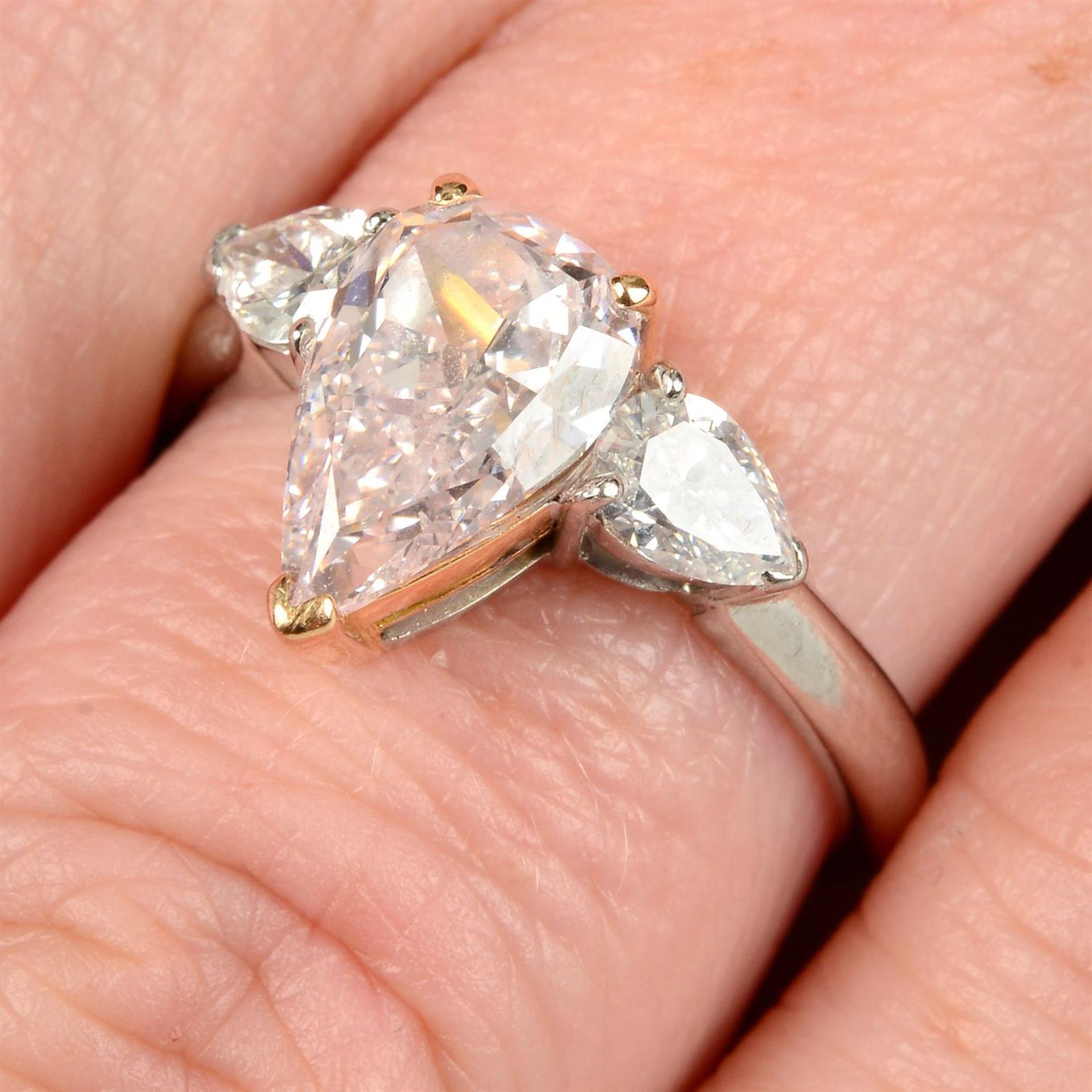An 18ct gold Fancy Light Pink pear-shape diamond ring, with pear-shape diamond sides.