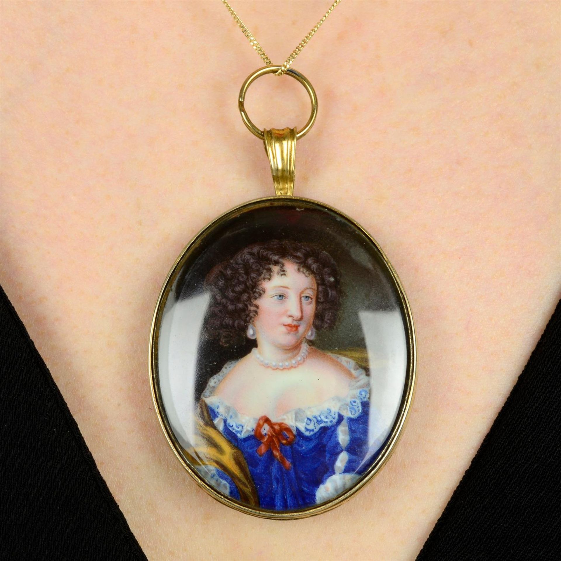 A 19th century portrait miniature pendant, depicting a lady in blue dress.
