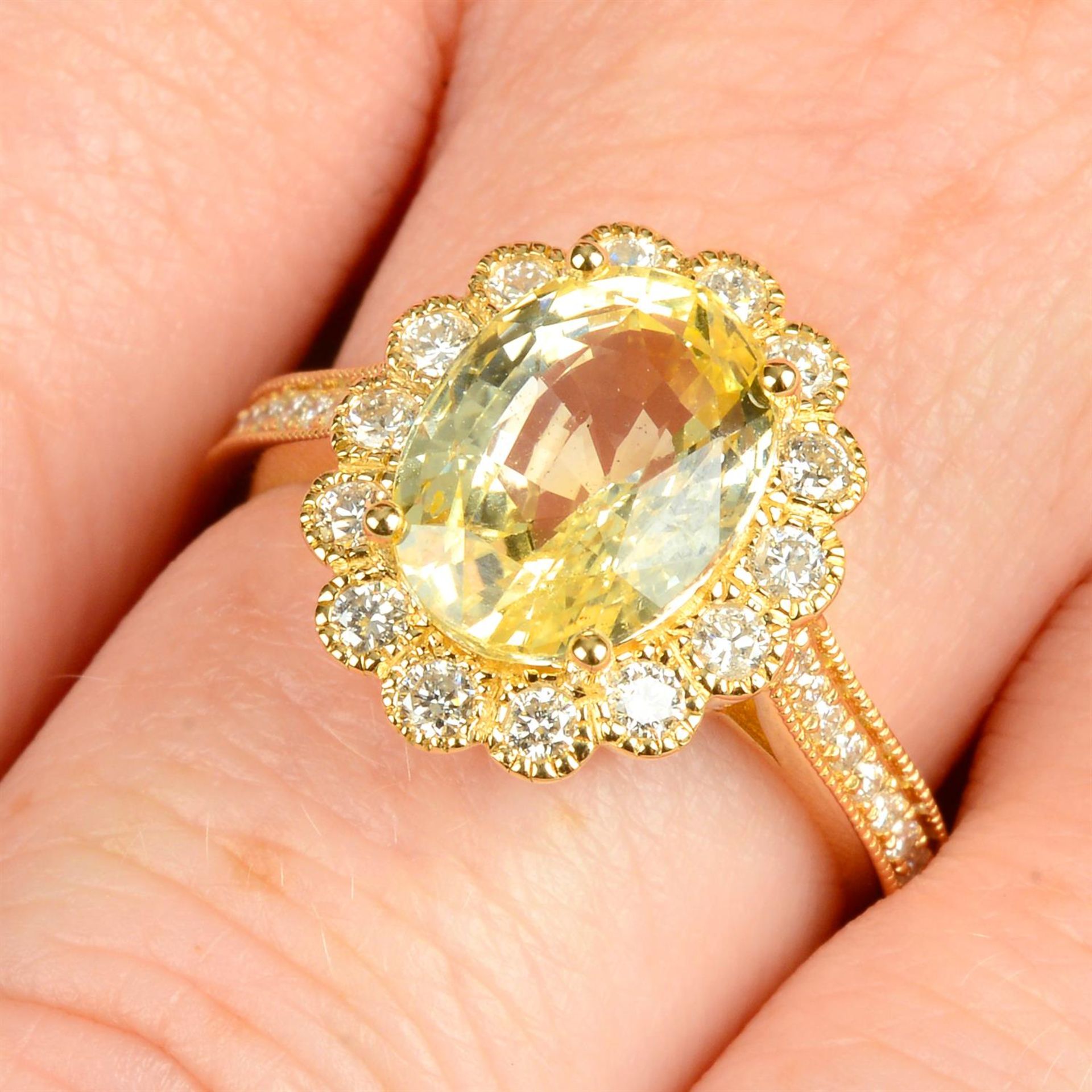 An 18ct gold yellow Sri Lankan sapphire and diamond cluster ring.