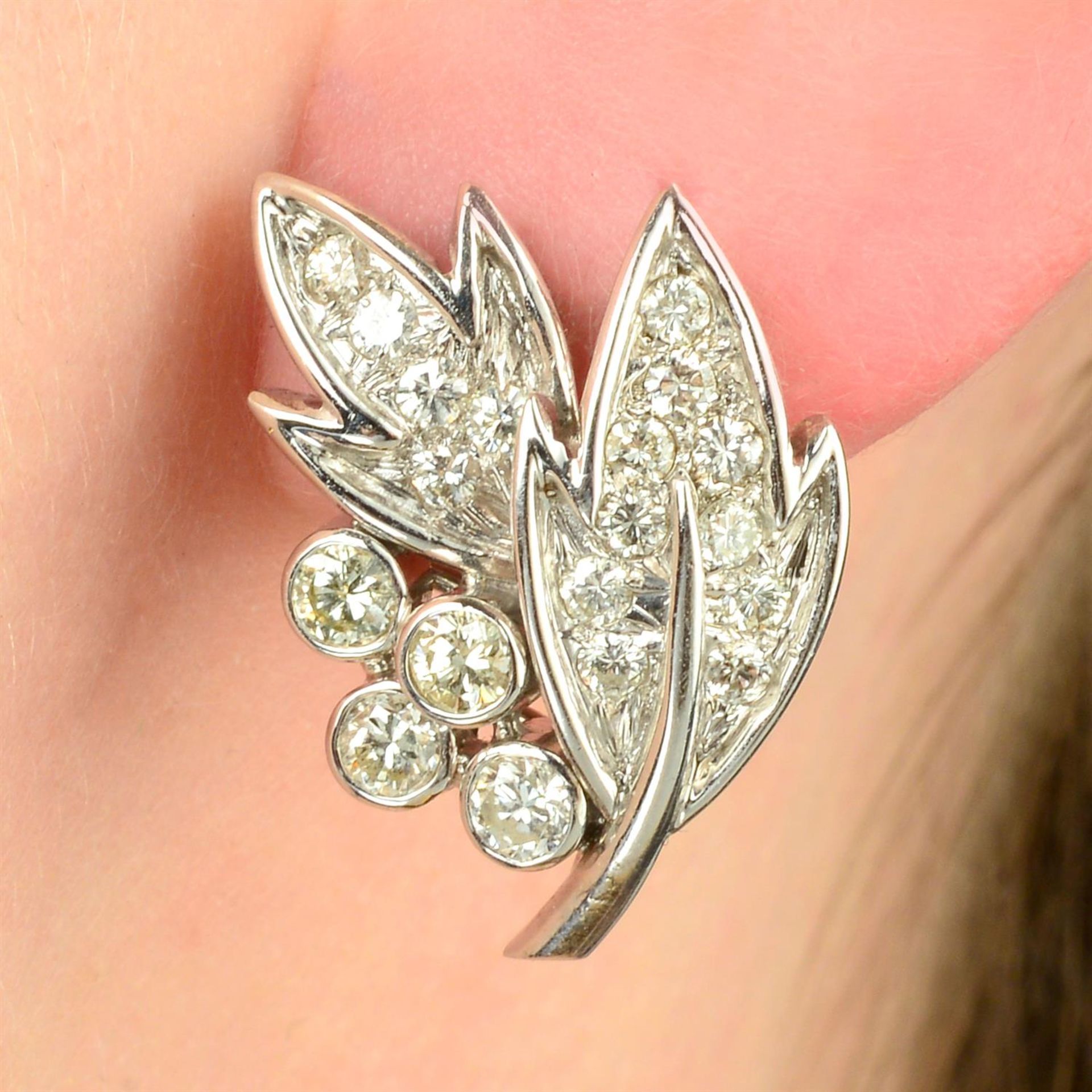 A pair of diamond foliate earrings.
