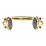 A 9ct gold cuff bangle, with sapphire and moonstone terminals.