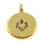 An early 20th century 15ct gold locket, with ruby fleur-de-lis highlight.