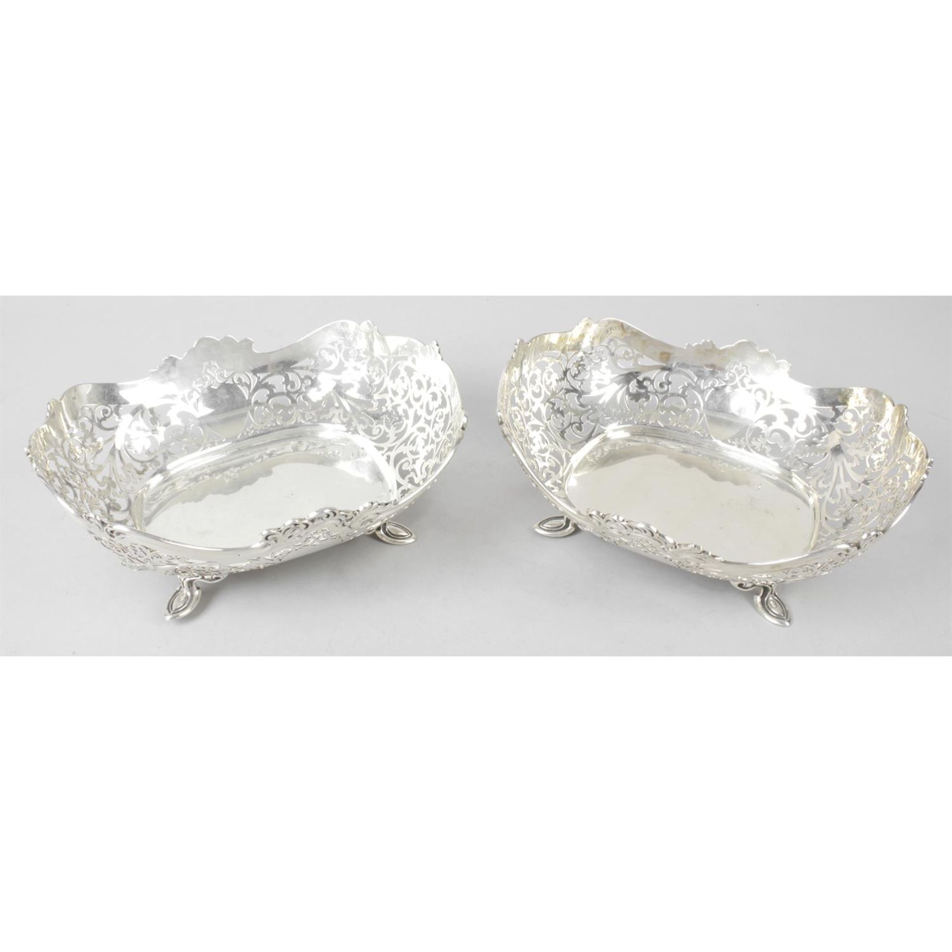 A pair of George V silver pierced dishes, on foliate feet.