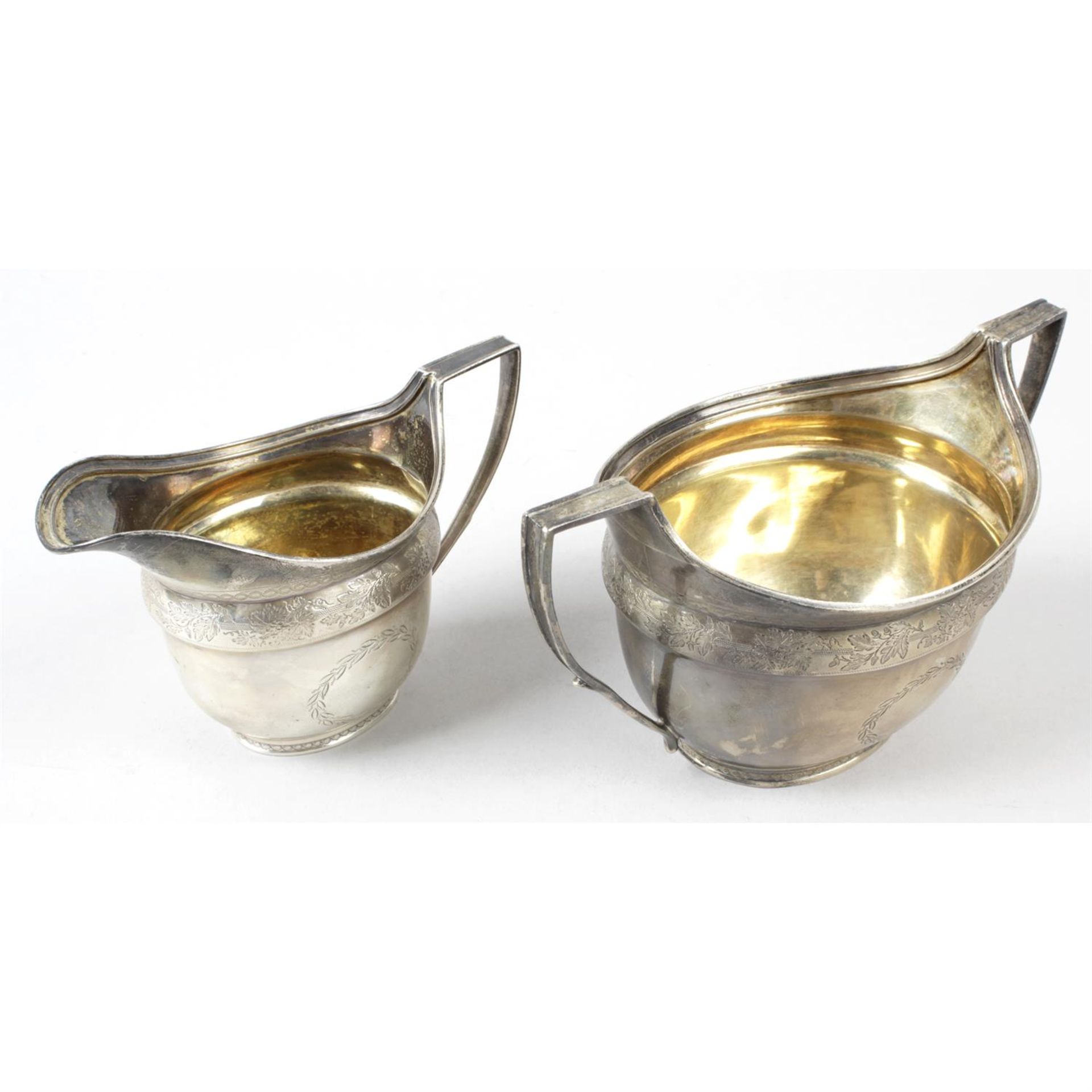 A George III silver twin-handled sugar bowl & matching cream jug.
