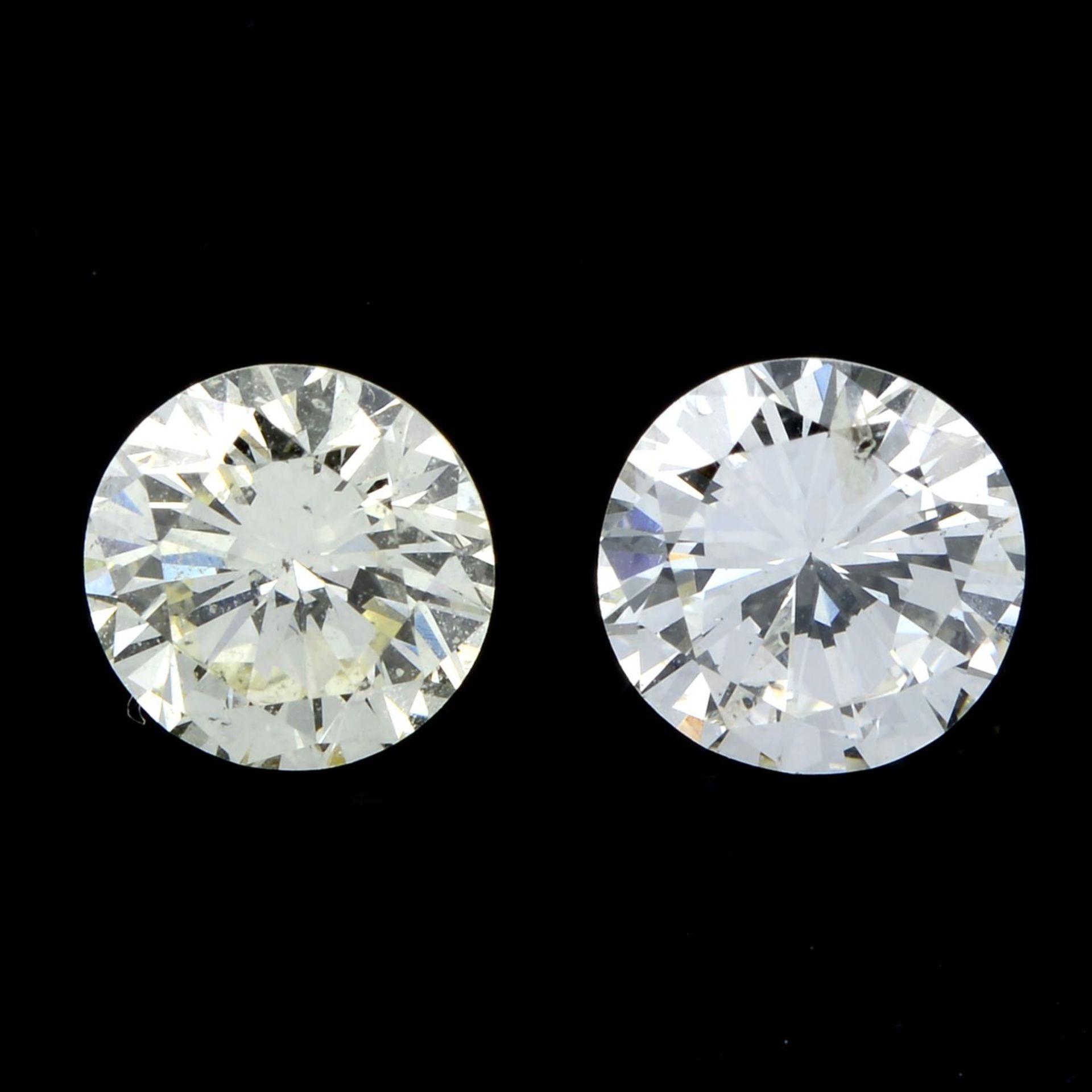 A pair of brilliant-cut diamonds, weighing 1.03ct. Estimated to be tinted colour and I1 clarity and