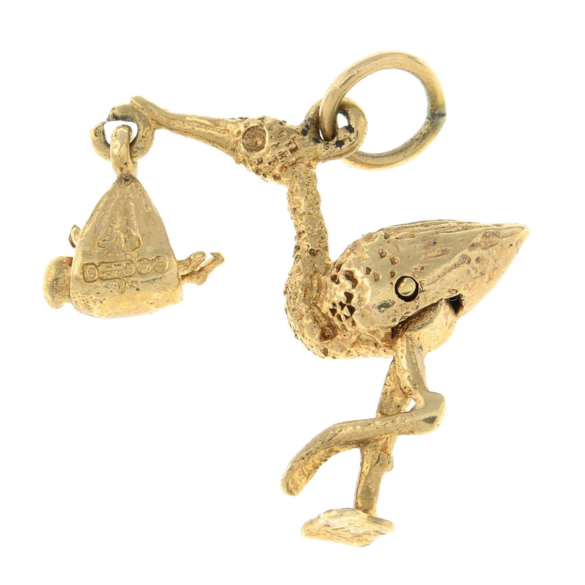 A 1960s 9ct gold charm, designed as a textured stork, delivering a new born baby. - Image 2 of 2