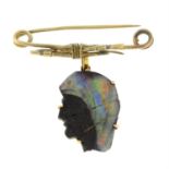 A canoe paddle brooch, suspending a boulder opal cameo drop, depicting a gentleman in profile.