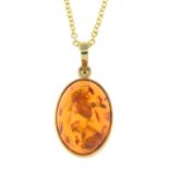 A 9ct gold modified amber cabochon pendant, with 18ct gold chain.