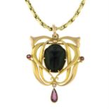 An early 20th century 9ct gold scarab beetle pendant, suspending a garnet drop, with 9ct gold