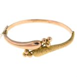 A late Victorian 9ct gold textured hinged bangle.
