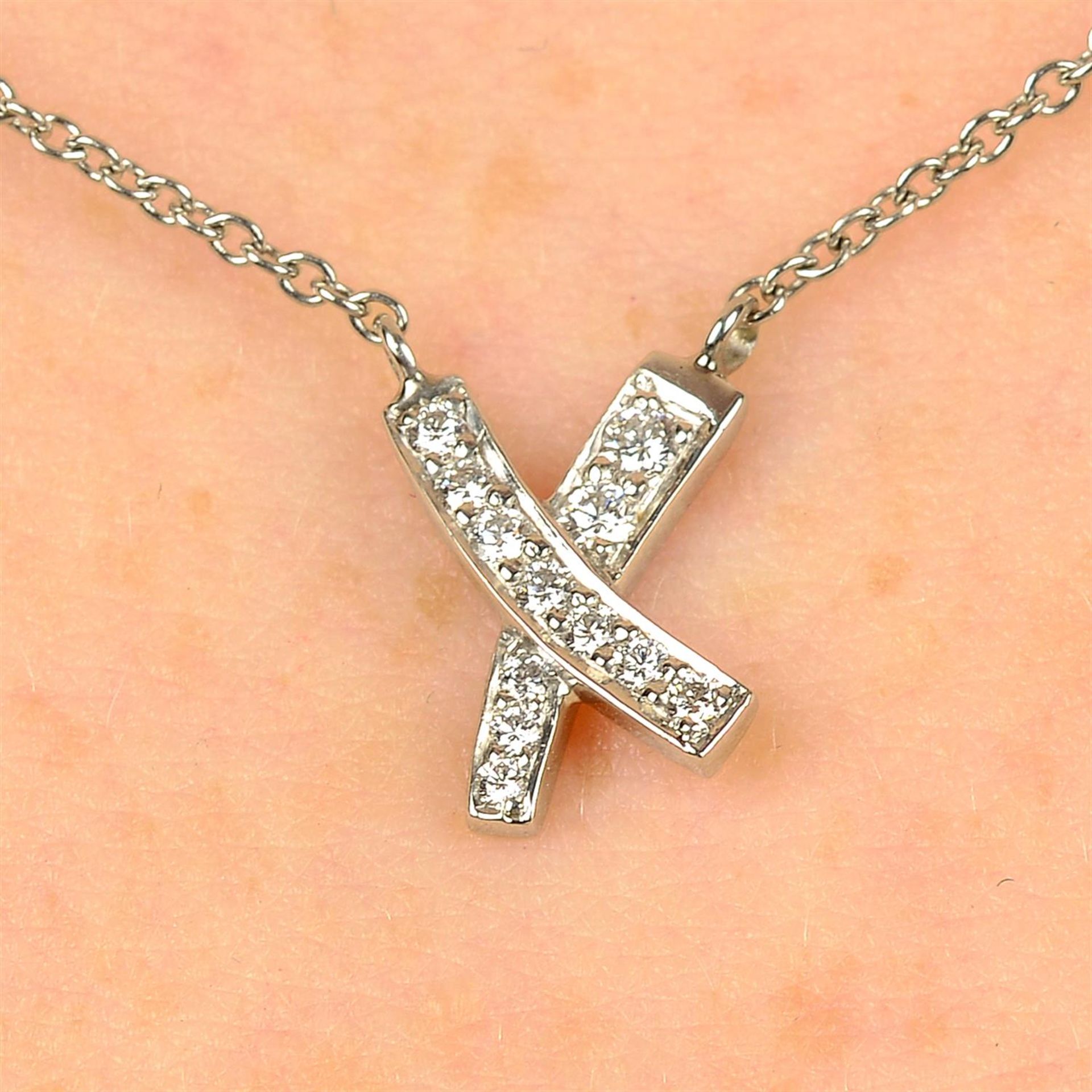 A diamond 'Kiss' cross pendant, on chain, by Paloma Picasso for Tiffany & Co.