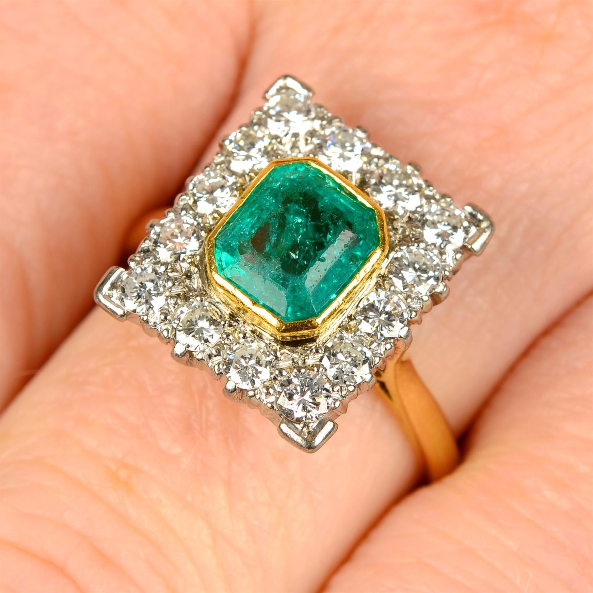 An emerald and diamond cluster ring.