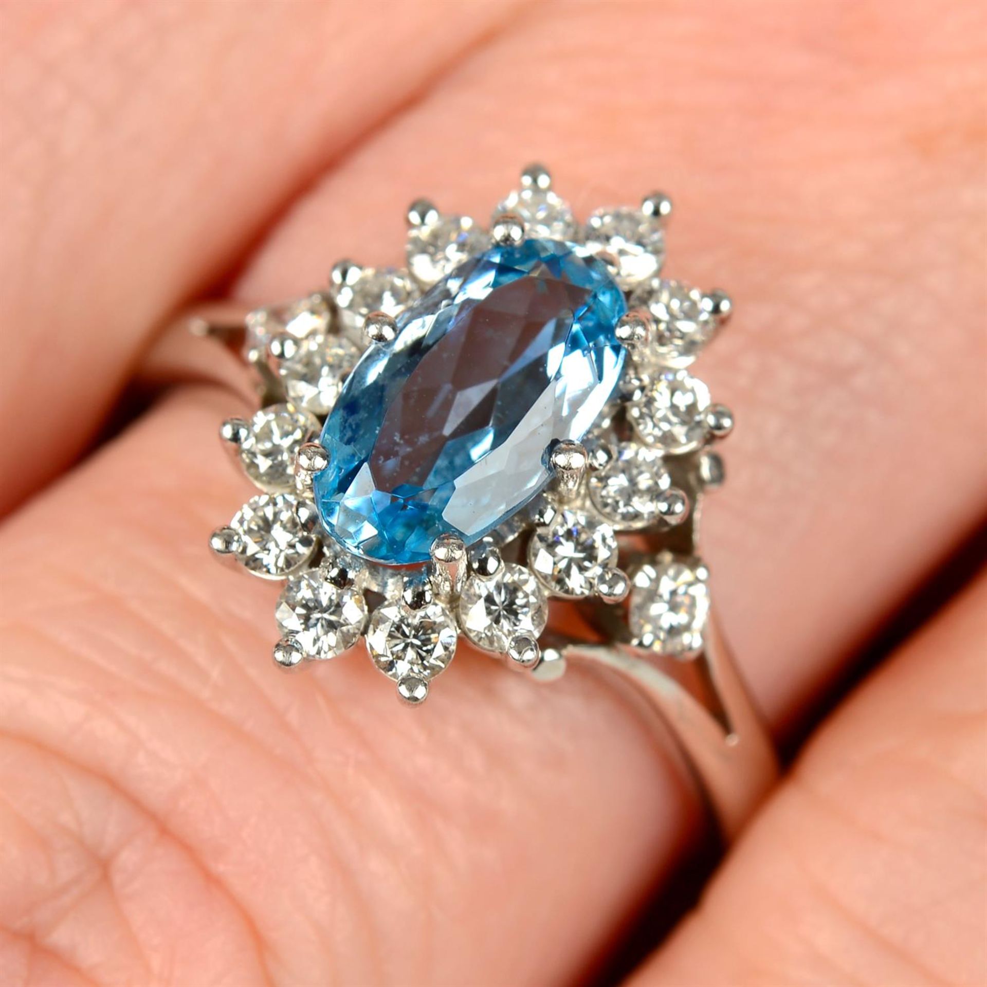 A platinum, aquamarine and brilliant-cut diamond cluster ring.