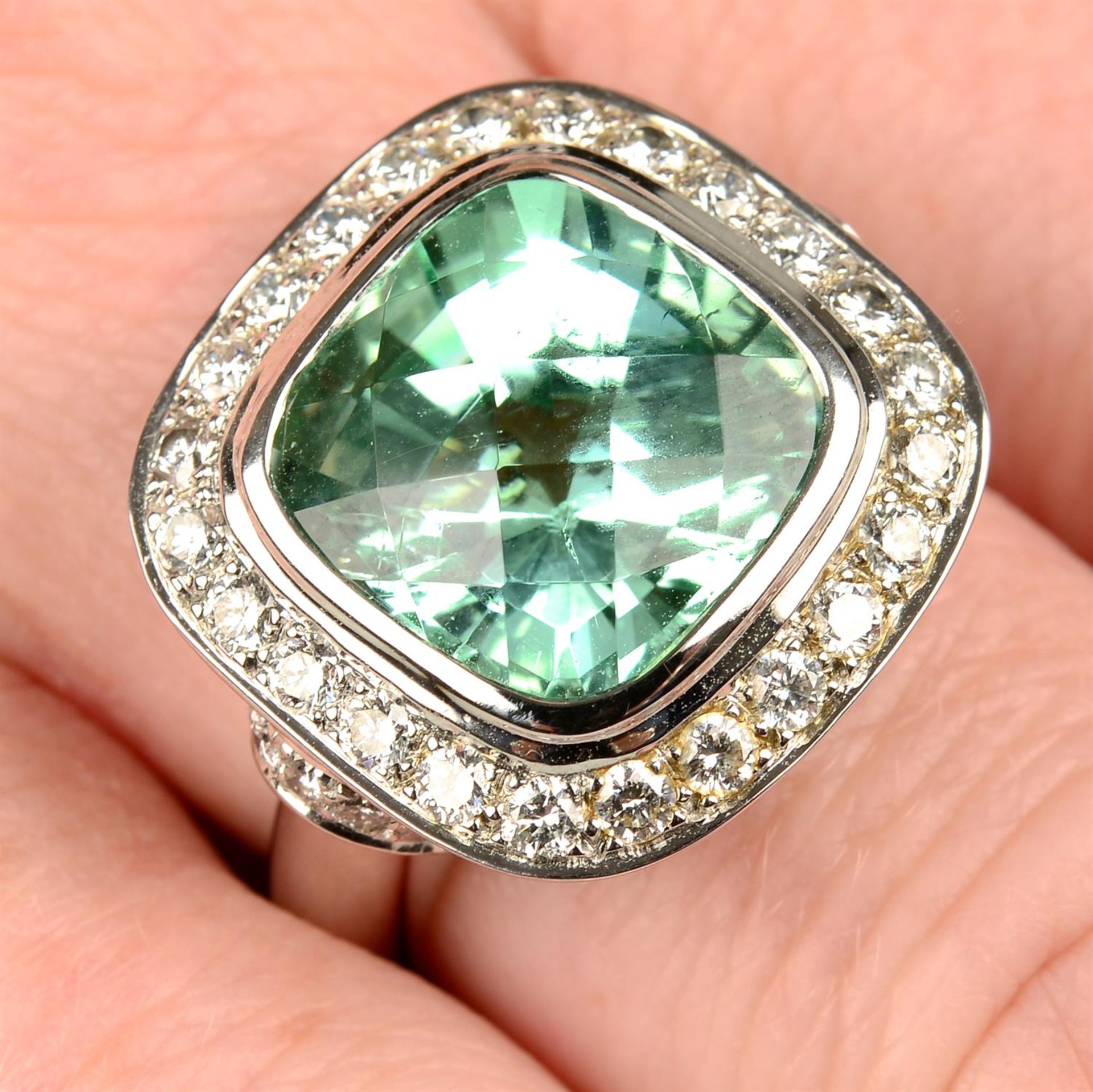 An 18ct gold bluish green tourmaline and diamond dress ring, with 'pink' diamond highlight,