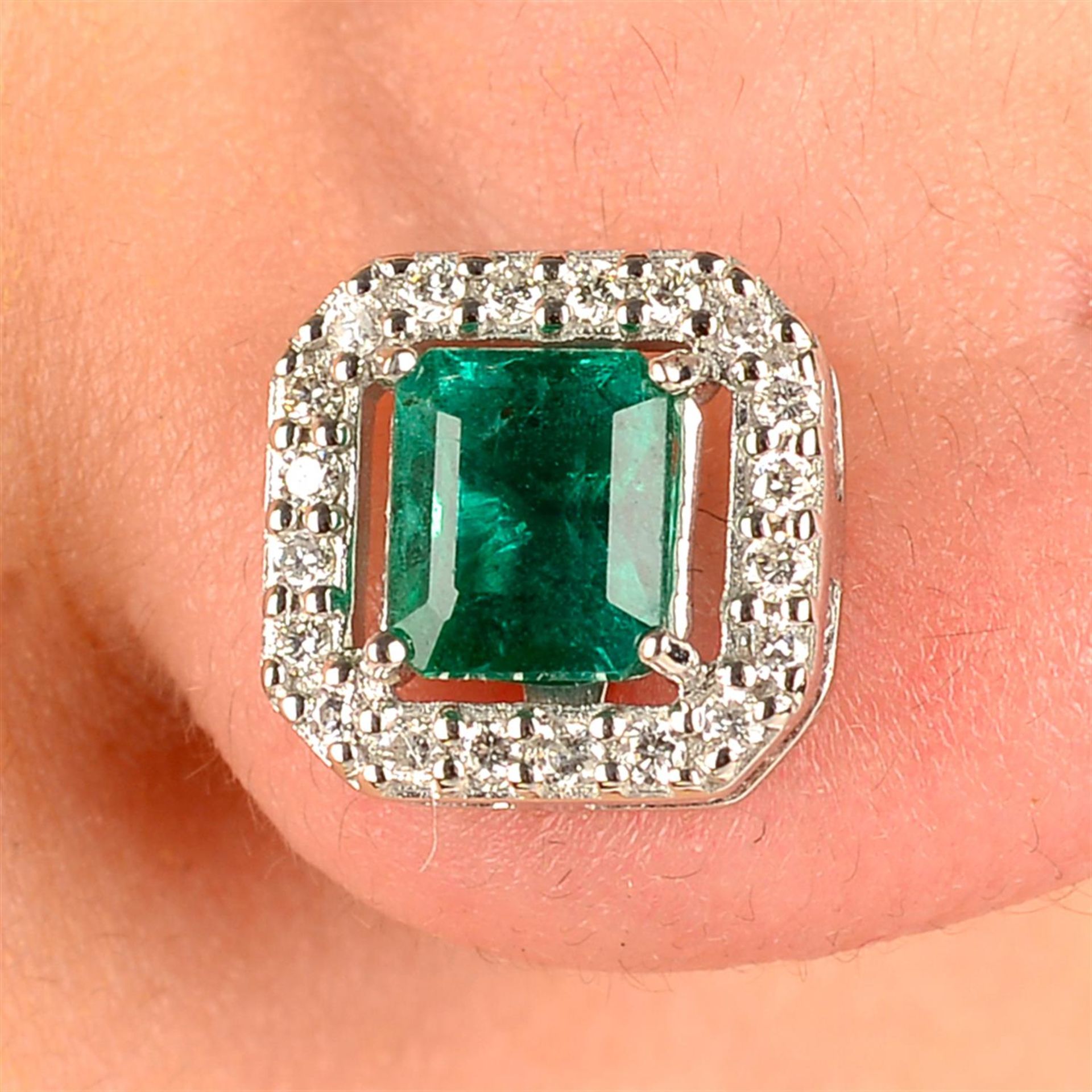 A pair of emerald and circular-cut diamond cluster earrings.