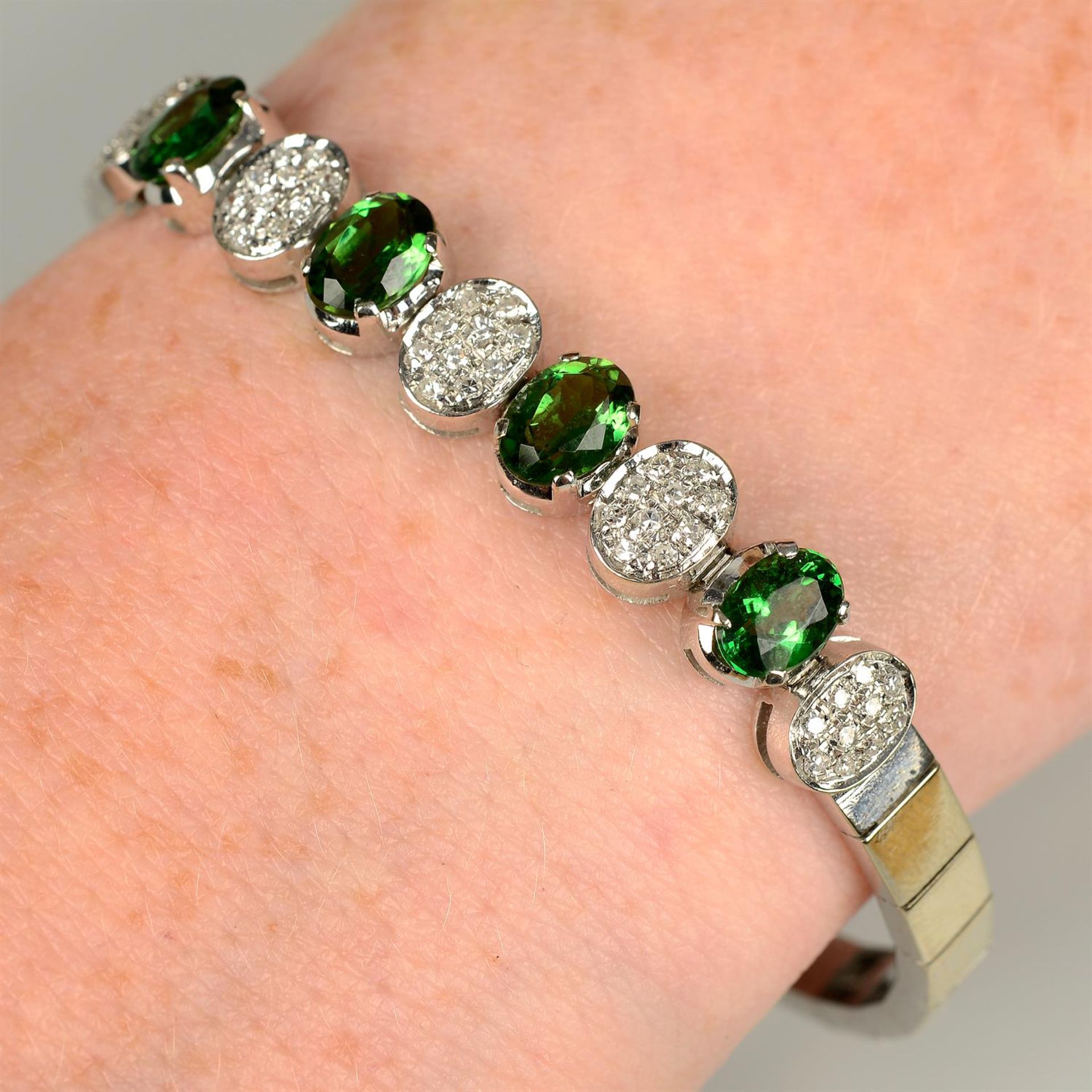 A 1970s 18ct gold green garnet and pavé-set diamond bracelet.