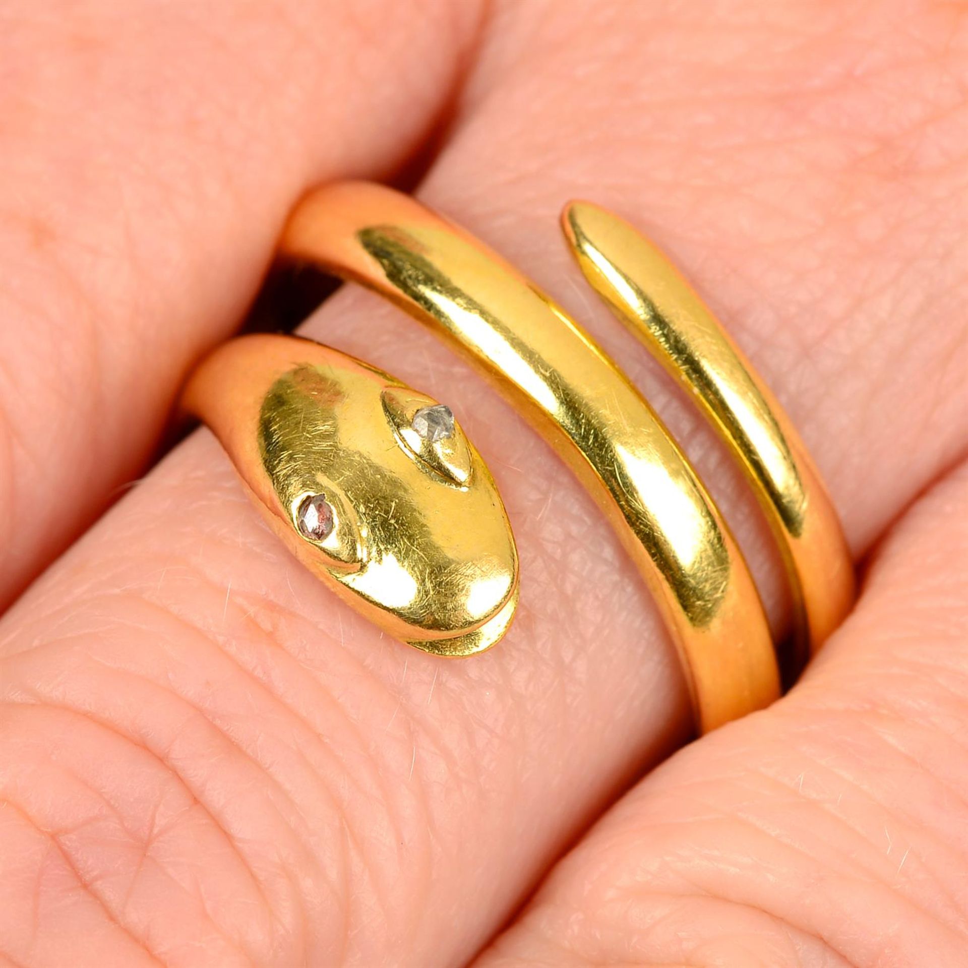 An 18ct gold snake ring, with diamond point eyes.