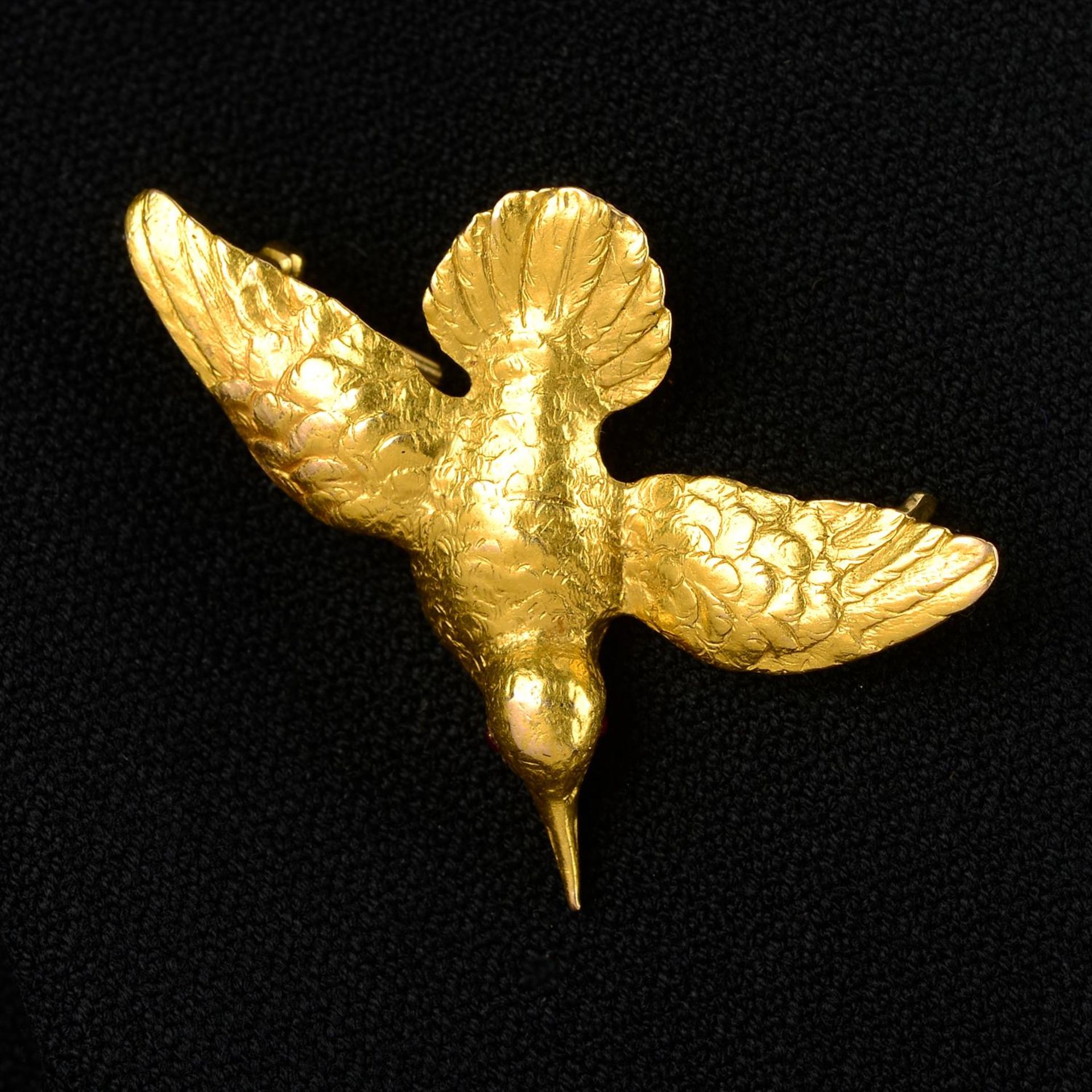 An early 20th century gold bird brooch, possibly a hummingbird, with ruby eyes.