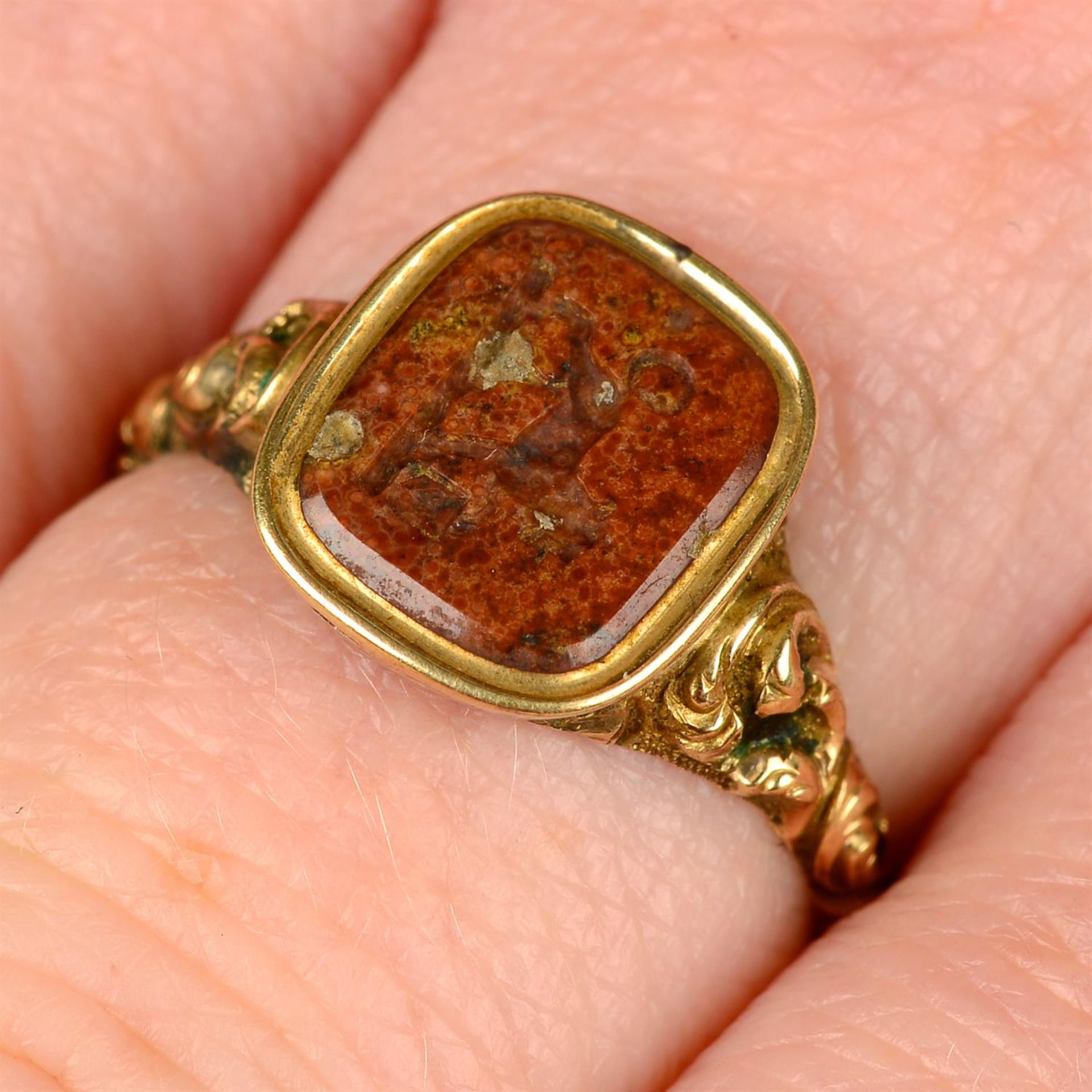 An early to mid 19th century gold agate intaglio signet ring, carved with a crest of a lion holding