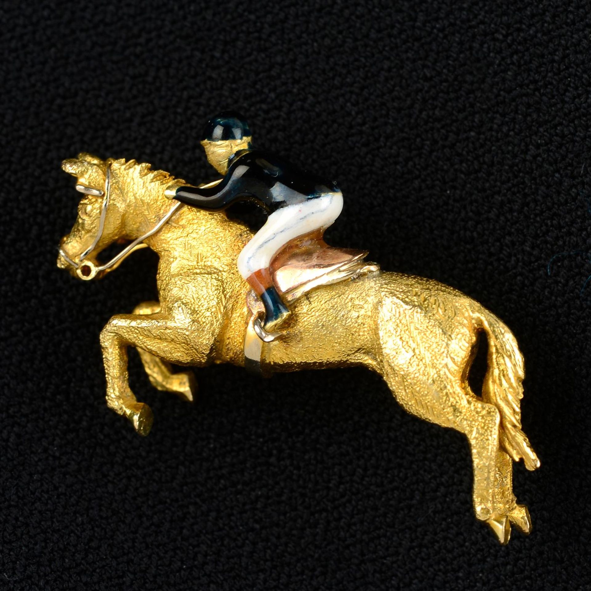 A 9ct gold and enamel brooch depicting a jockey on racehorse, by Alabaster & Wilson.