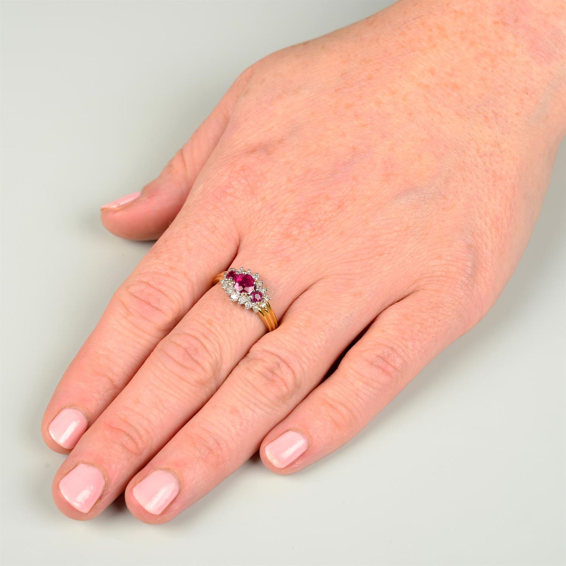 An 18ct gold graduated ruby three-stone ring, with brilliant-cut diamond surround. - Image 5 of 5