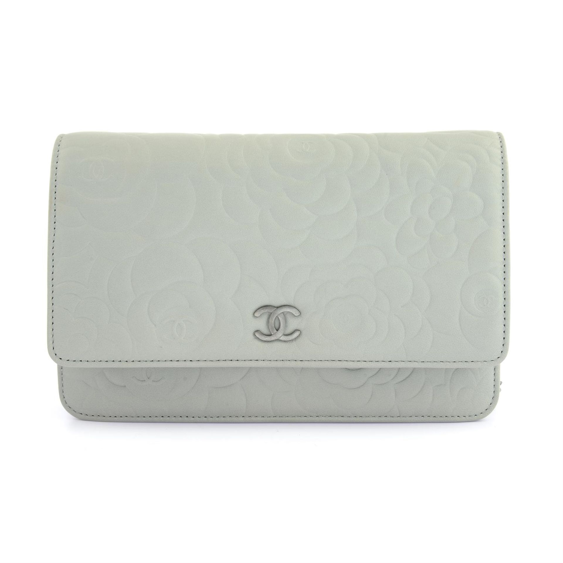 CHANEL - a light grey Camelia embossed leather wallet on chain.