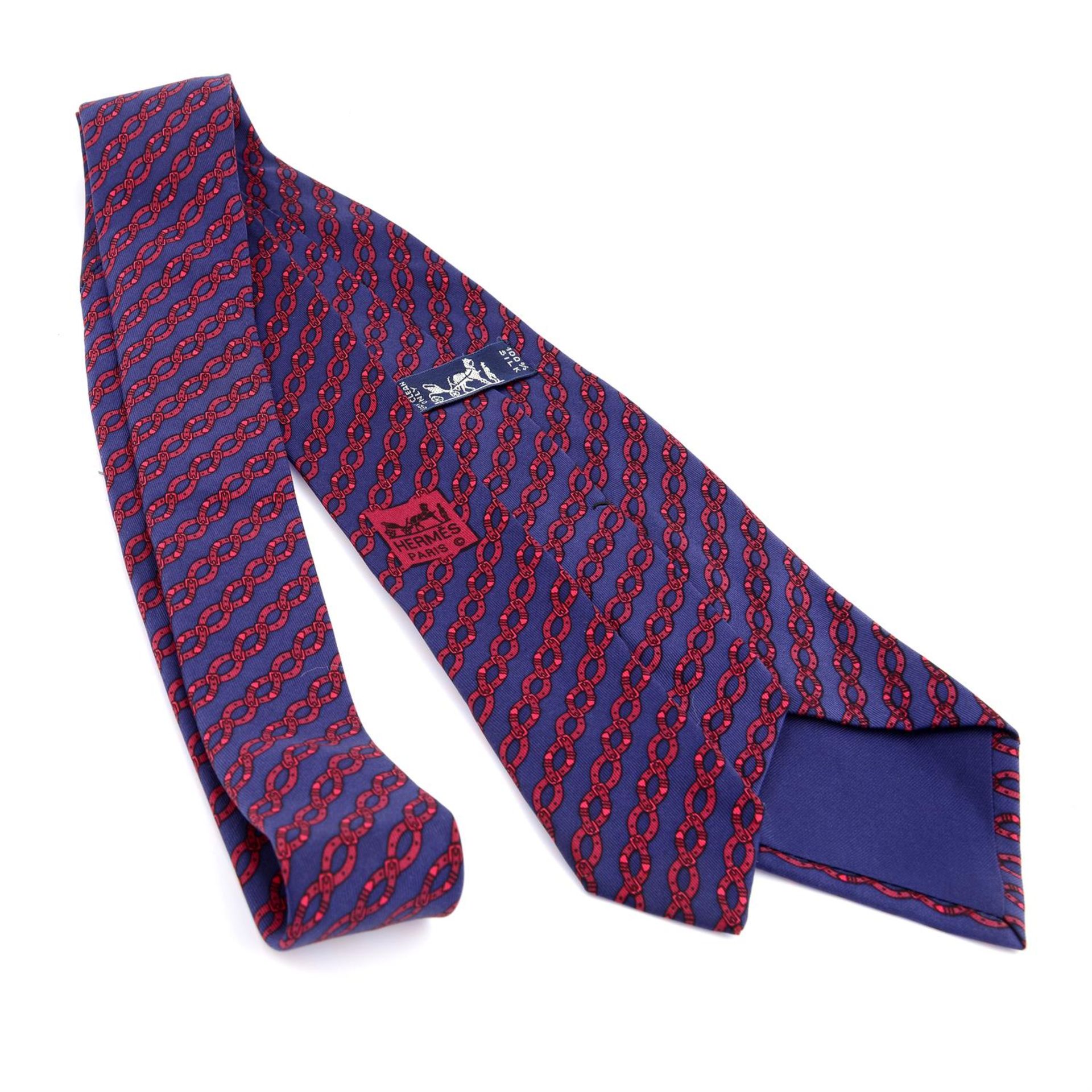 HERMÈS - a blue and red chain print silk tie. - Image 2 of 2