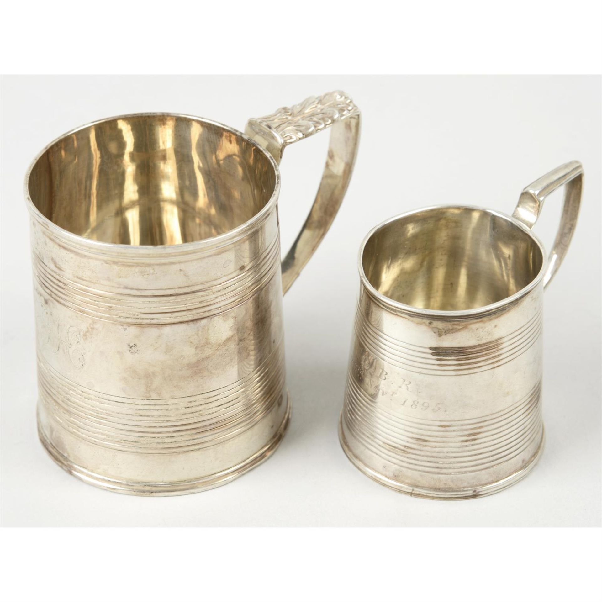 A late George III silver christening mug; together with a similar smaller example. (2).