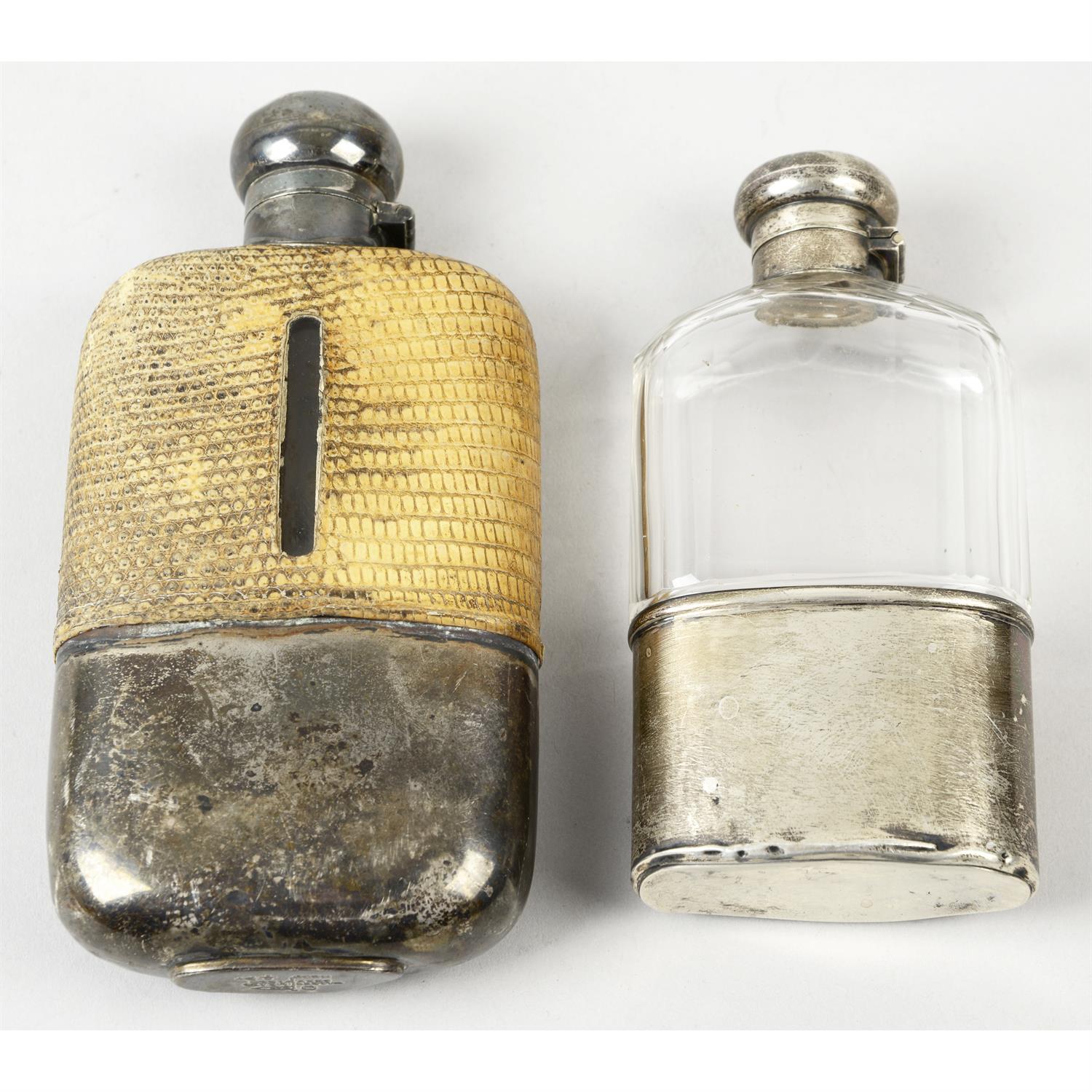 A late Victorian silver mounted & glass hip flask; together with an Edwardian example. (2).