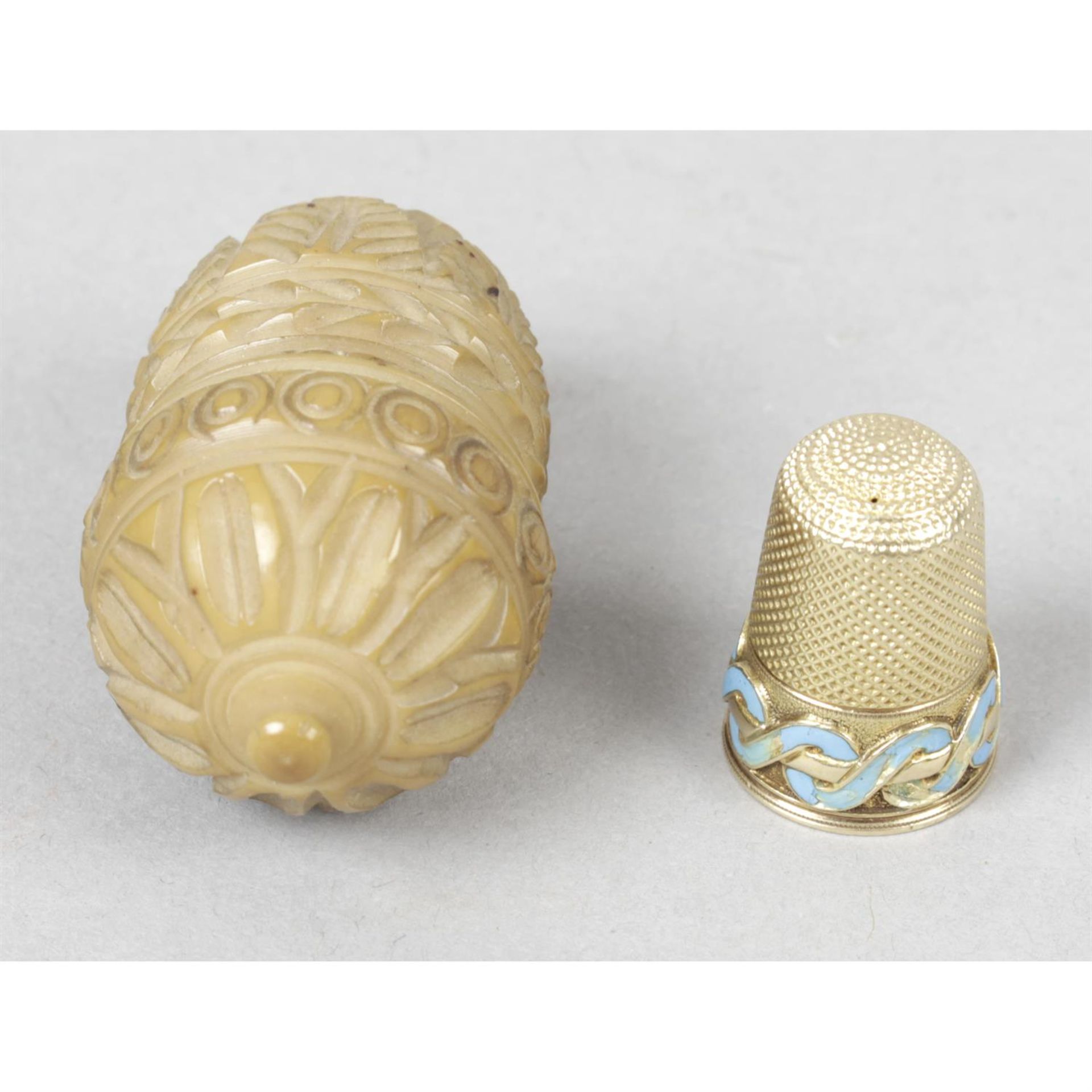 A late nineteenth century carved Coquilla nut and gold thimble.