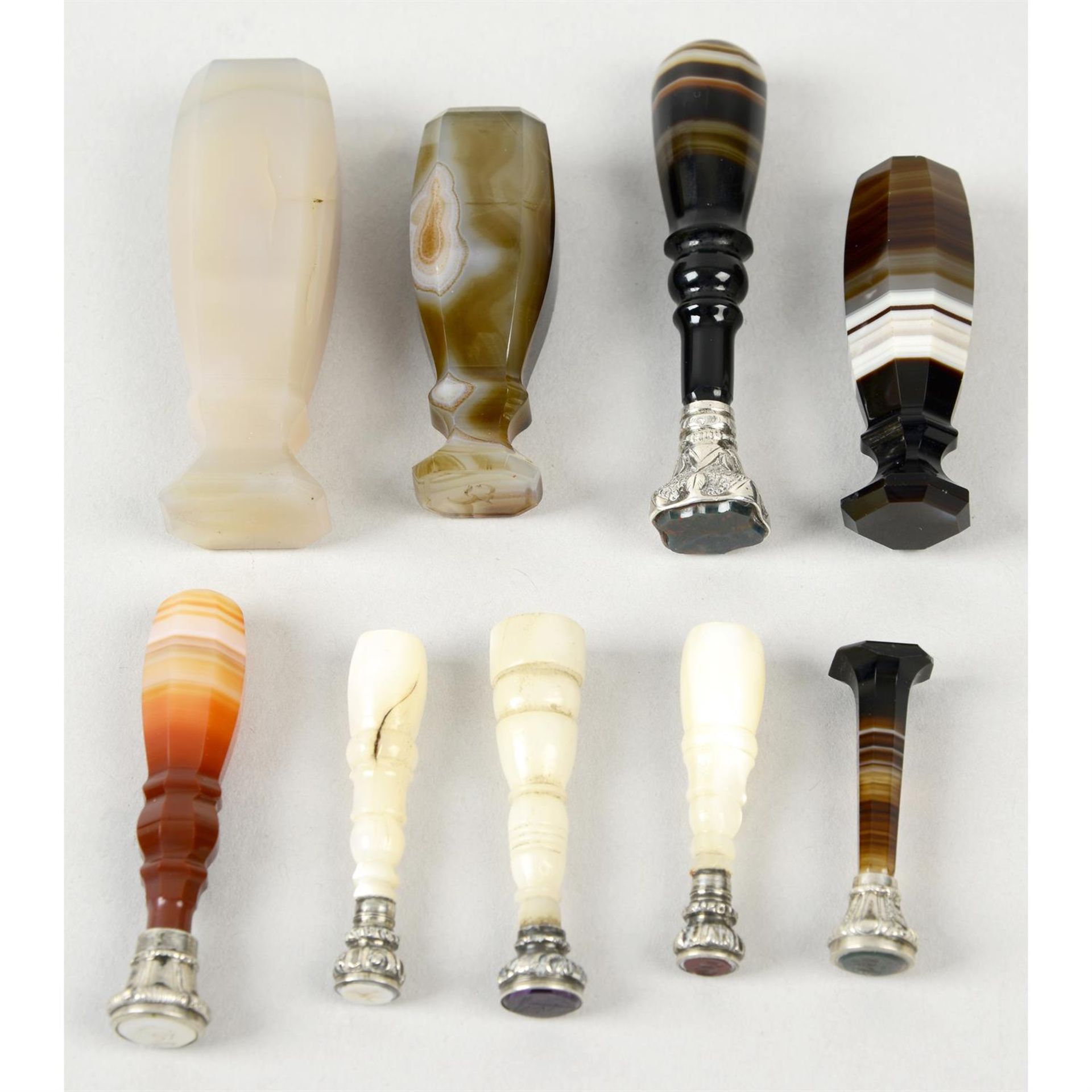 A selection of nine banded agate, onyx & mother-of-pearl standing seals. (9).