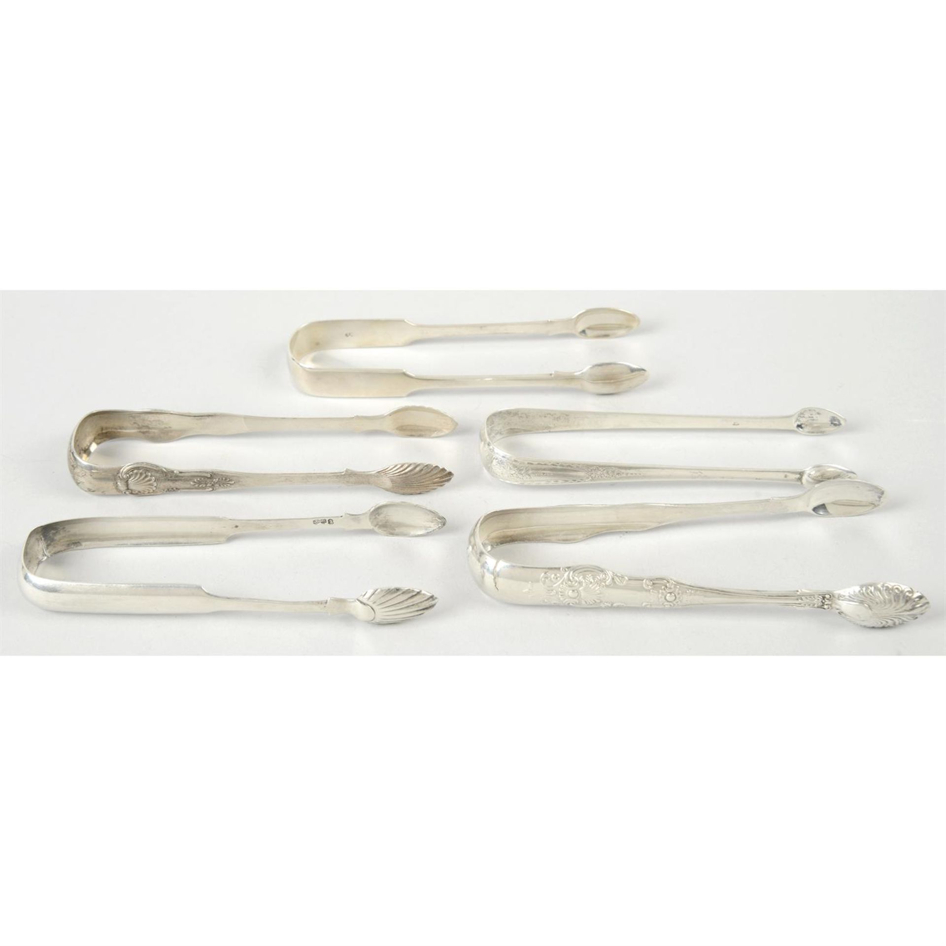 Four pairs of Scottish silver sugar tongs; together with a London hallmarked pair. (5).