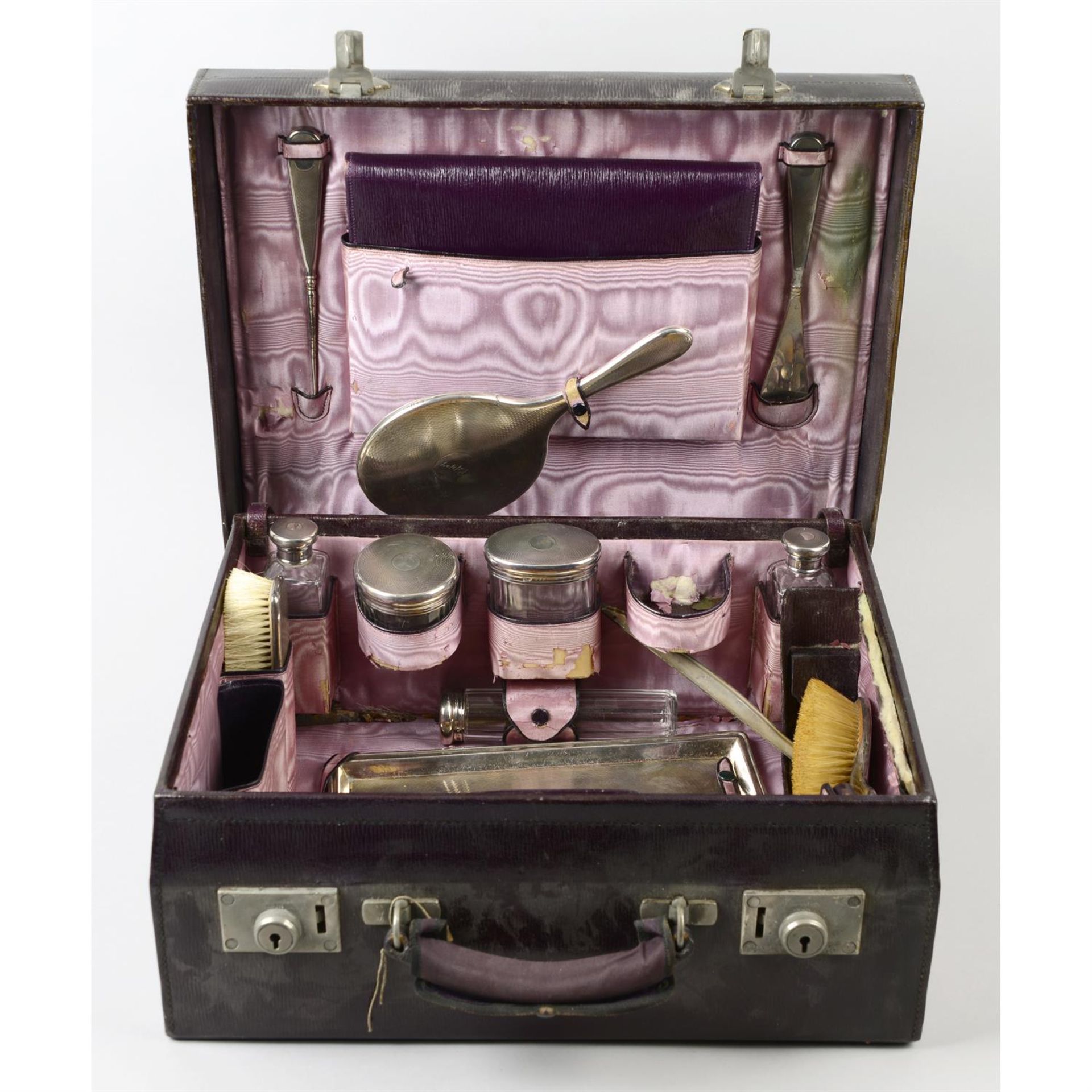 A part travelling vanity set with silver mounts, in leather case. (12)