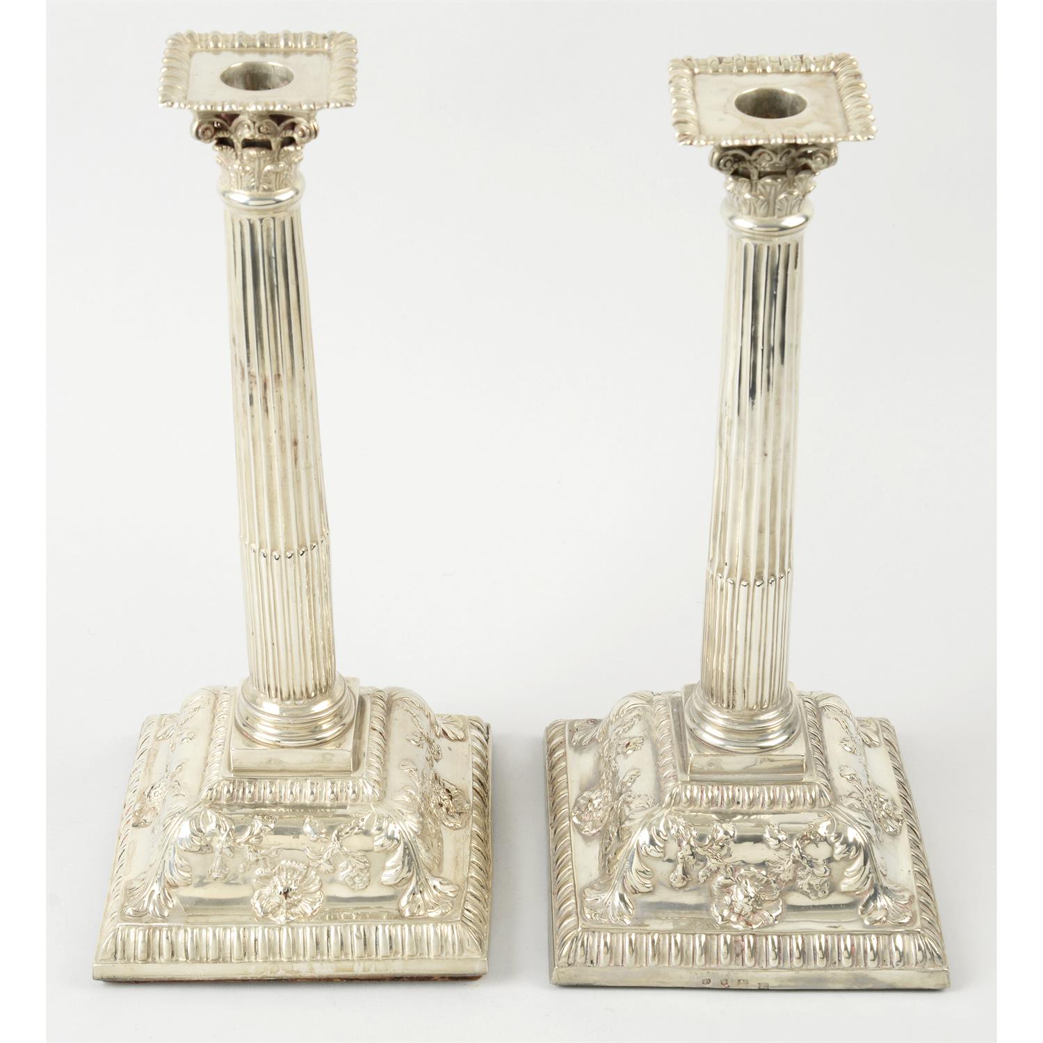 A pair of silver Corinthian column candlesticks (filled).