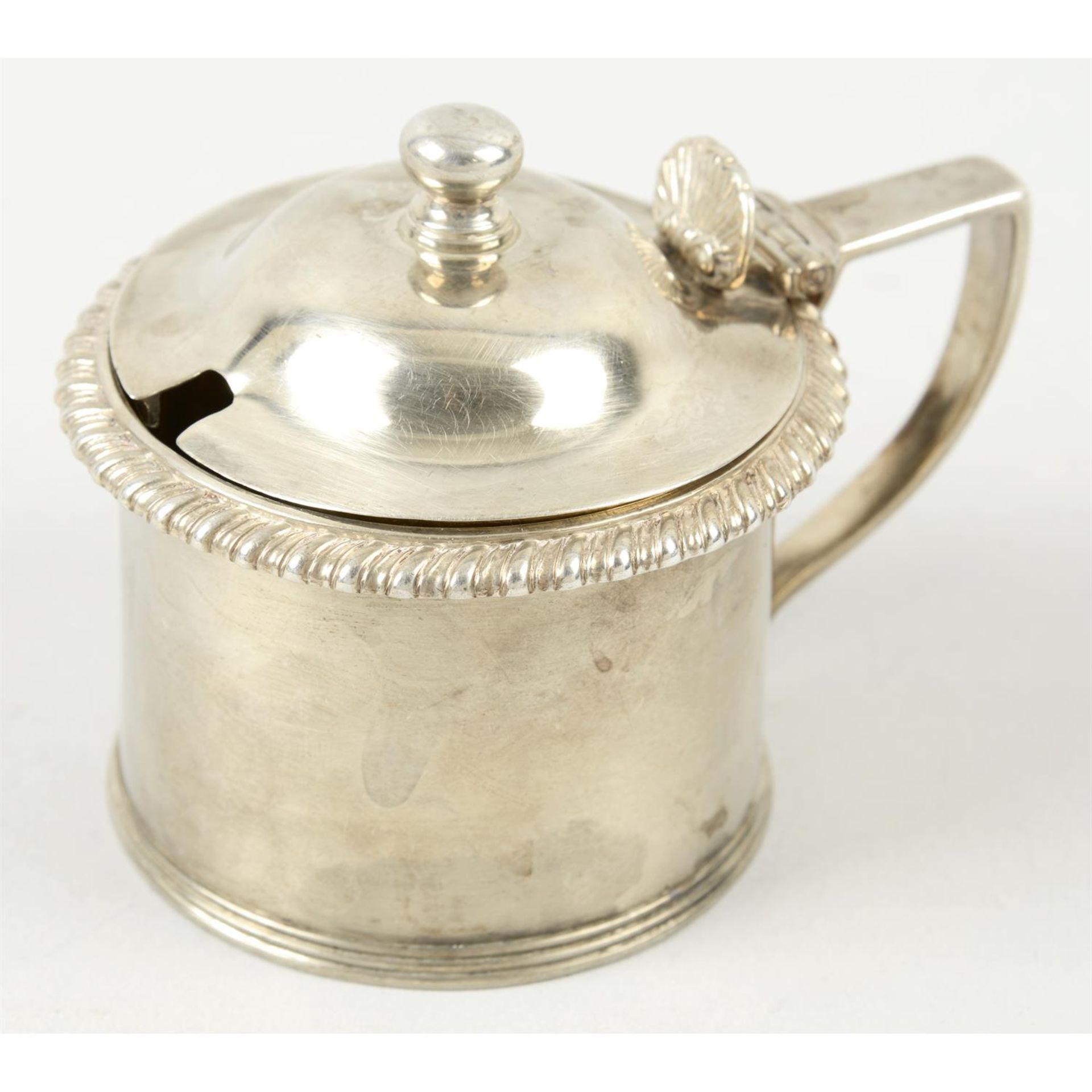A George IV silver mustard pot; together with four pierced open salts (all missing glass liners).