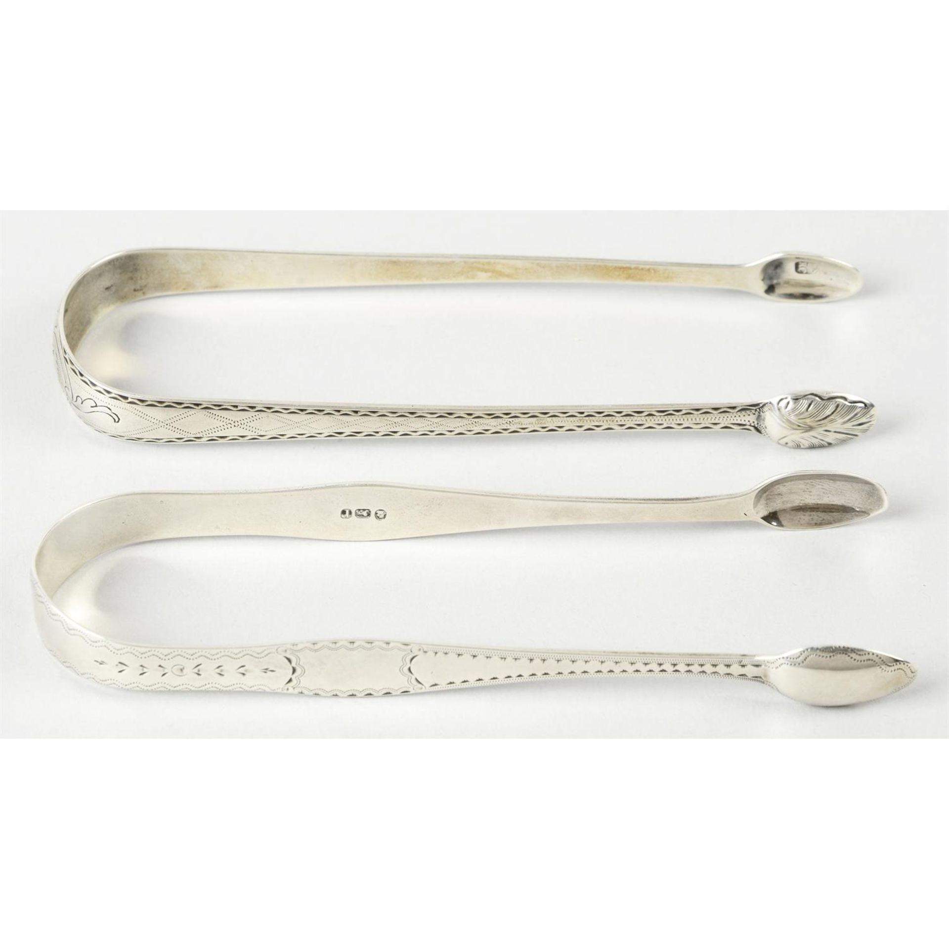 Two pairs of bright-cut engraved George III silver sugar tongs. (2).