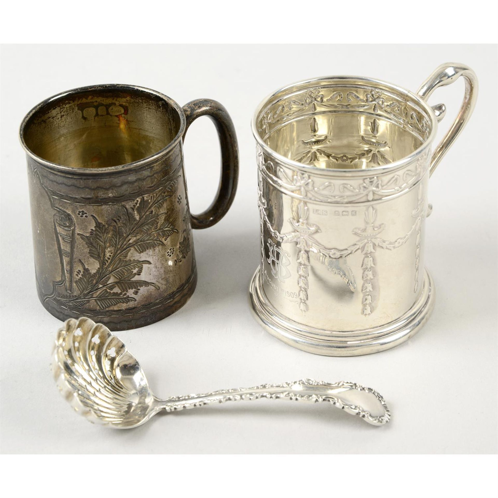 Two Edwardian silver christening mugs, and small shell bowl sifter spoon. (3).