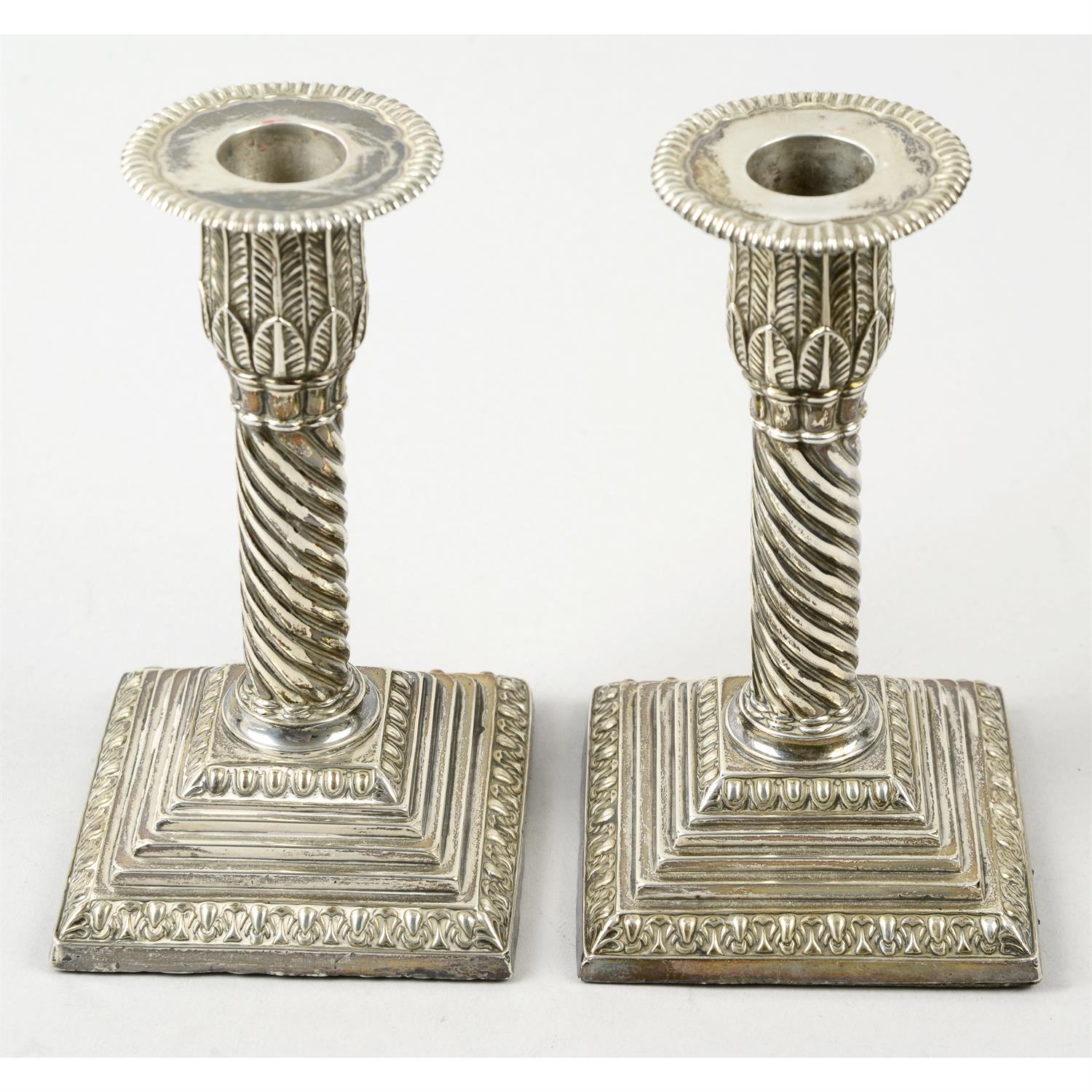 A pair of late Victorian silver mounted candlesticks; together with a selection of spoons, etc. (21)