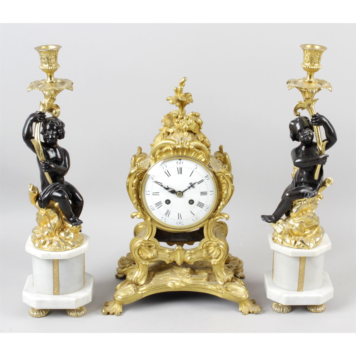 A 19th century gilt bronze cased mantel clock, together with a pair of bronze and gilt metal candle