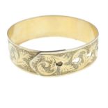 A silver belt bangle, with engraved scrolling motif, by Charles Horner.