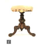 A Victorian circular seated rosewood piano stool, with turned pedestal above three carved scroll