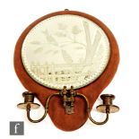 A late 19th and early 20th century circular wall mirror and sconce with reverse engraving of two
