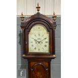 An early 19th Century mahogany longcase clock with an eight-day movement, the shaped hood with
